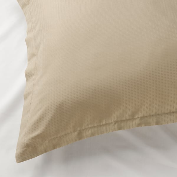 Tan pillowcase on white pillow, displaying smooth, dobby-patterned lyocell fabric, with an elegant hemmed edge.