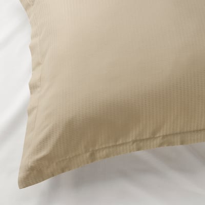 Tan pillowcase on white pillow, displaying smooth, dobby-patterned lyocell fabric, with an elegant hemmed edge.