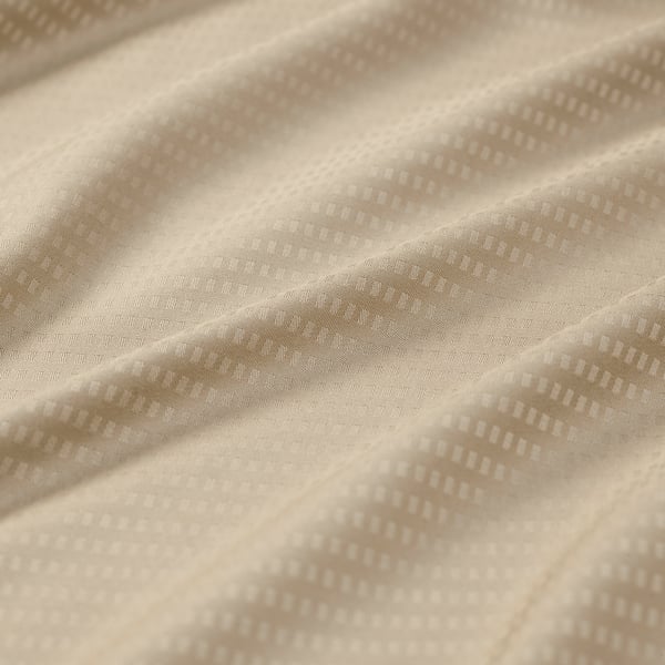 Close-up of soft, patterned beige pillowcase, likely made from smooth, natural lyocell fabric.