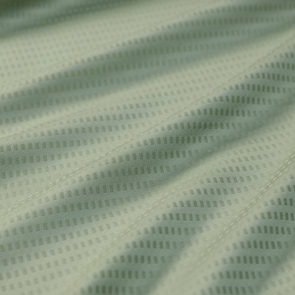 Close-up of soft, patterned pillowcase in light green, showcasing its textured dobby-effect and smooth fabric quality