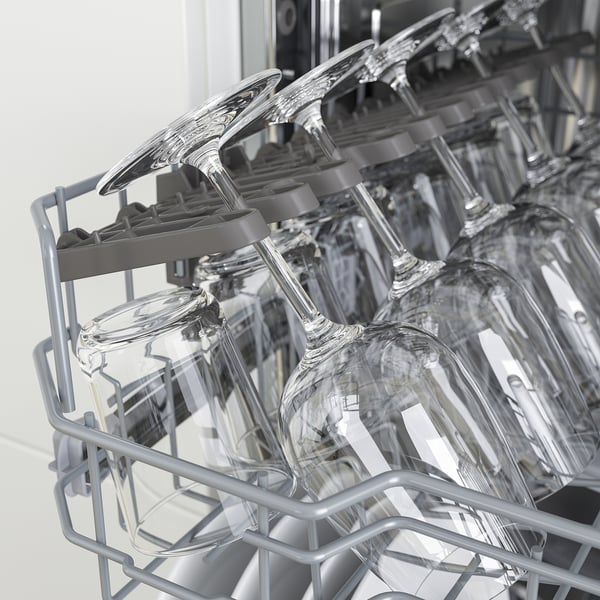 Clean wine glasses neatly arranged in an upper dishwasher rack, indicating an organised and efficient dishwashing process.