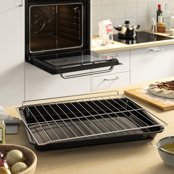 A modern kitchen with an oven, featuring wire racks and baking tray, suitable for cooking and baking.