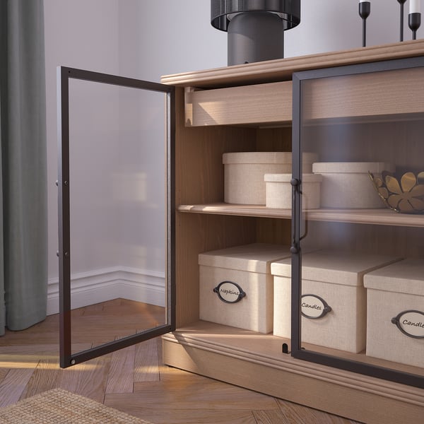 Open wooden cabinet with glass doors displays neatly organised boxes, indicating storage and organisation functions.