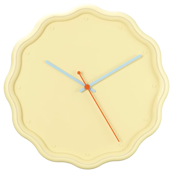 A colourful clock in yellow, orange, and white with a petal-shaped design and plastic construction.