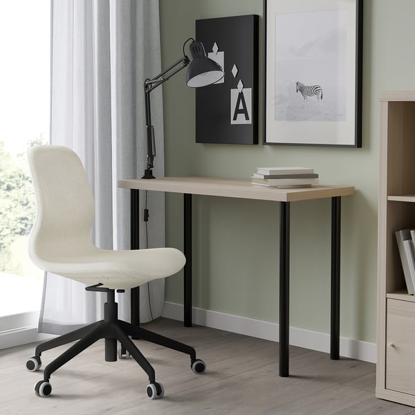 Modern home office: LINNMON desk, swivel chair, wall art, lamp & books.
