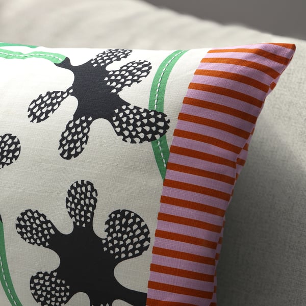 A decorative pillow with intricate embroidered flowers and striped sides, showcasing high-quality craftsmanship.