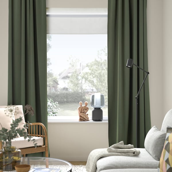 Living room with dark green MAJGULL curtains, lamp, and wooden chair by window.
