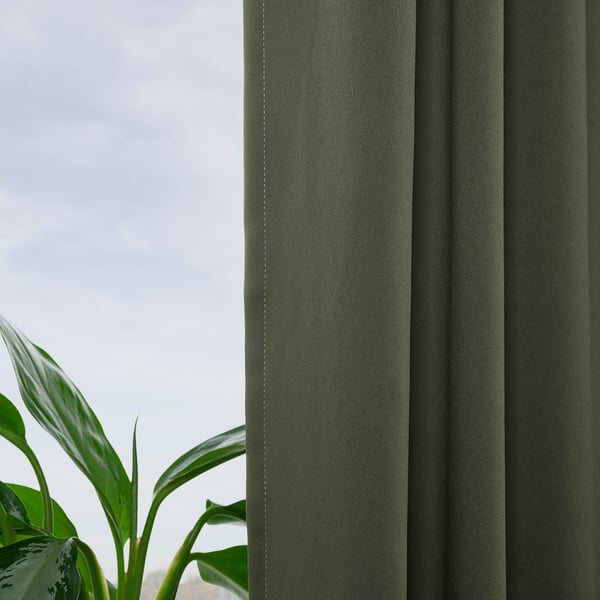 Green block-out curtains with a smooth texture, offering privacy and light control, as seen in.