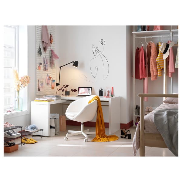 Bright, white MALM desk with yellow scarf, featuring a pull-out panel and adjustable lamp, set in a cosy room with a bed.