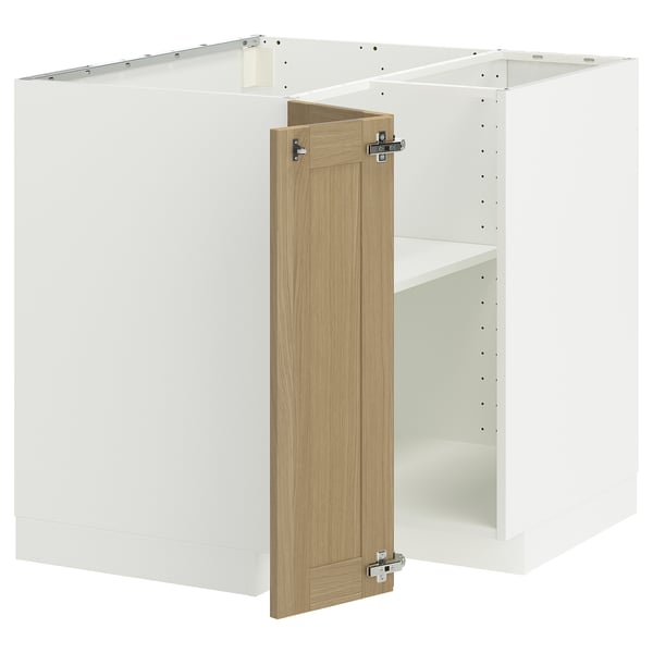 A white METOD kitchen unit with oak doors partially open, revealing shelves inside.