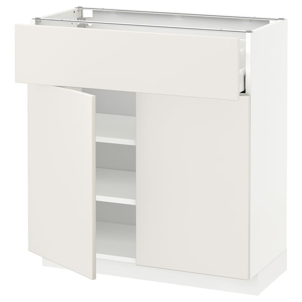 A white METOD kitchen cabinet with veddinge fronts. It has a sleek, modern design with one open door revealing adjustable shelves.