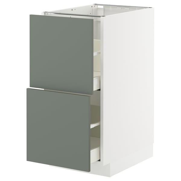 Modern kitchen cabinet with grey-green drawers and white frame.