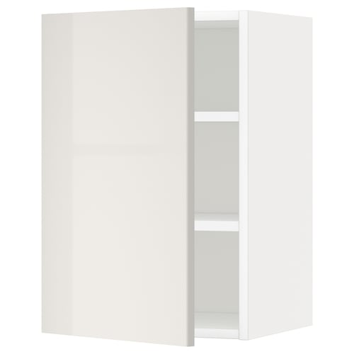 A white, glossy kitchen cabinet from the METOD system, showcasing a sleek design with an adjustable shelf and a reversible door.