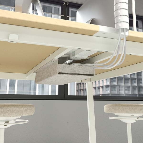 Modern high conference table with integrated footrests and cable management system for meetings.