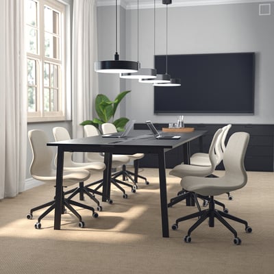 Modern conference room with black table, swivel chairs, laptops, pendant lights, window, blackboard, carpeted floor.