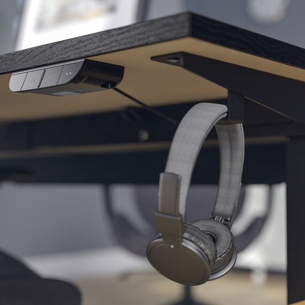 Headphones hang on desk hook, control sits above.