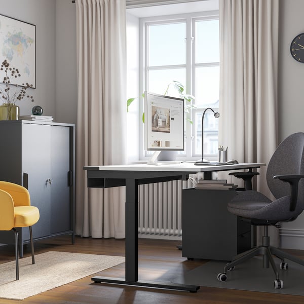Home office with MITTZON black desk, grey & yellow chairs, large window, white curtains.