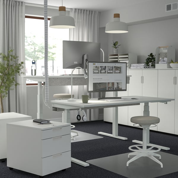 Modern home office with MITTZON desk, dual monitors, laptop, and pendant lights.