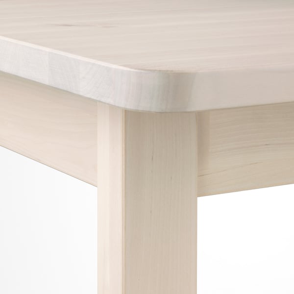 Light wooden table corner, smoothly rounded edges. Crafted with fine birch grain, its sturdy and stylish.