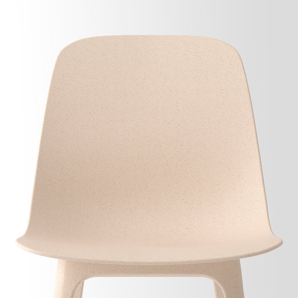Beige chair, smooth, rounded curves, textured surface, inviting.