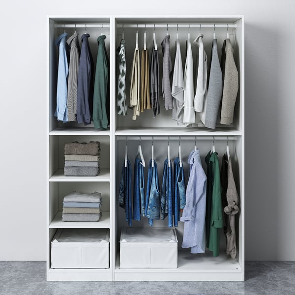 A neatly organised wardrobe with hanging shirts, folded sweaters, and storage boxes.