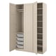 An open beige PAX wardrobe with organiser baskets and shelves.