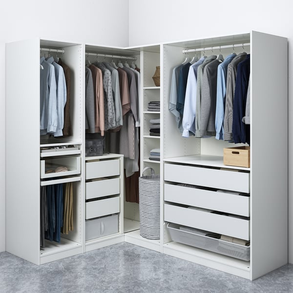 A white corner closet storing clothes, with shelves and drawers organising garments neatly.