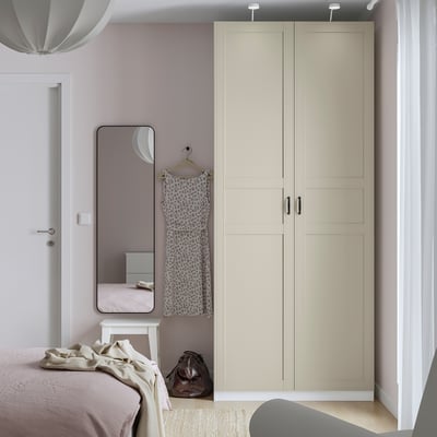 Modern bedroom with PAX wardrobe, mirror, and bed.