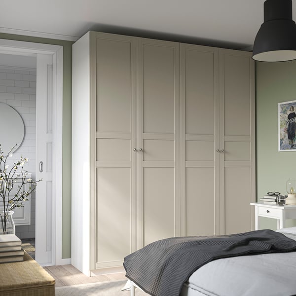 Modern bedroom with large beige PAX wardrobe, sleek bench, and dark bed.