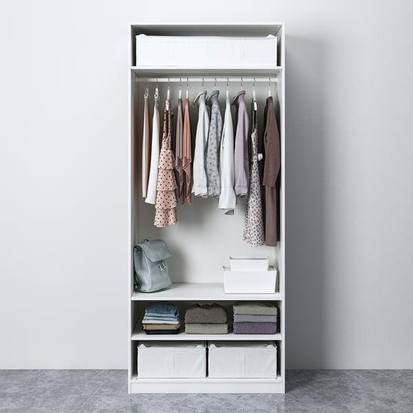 White wardrobe with clothes, backpack, and storage bins. Hangs and organises garments and accessories.