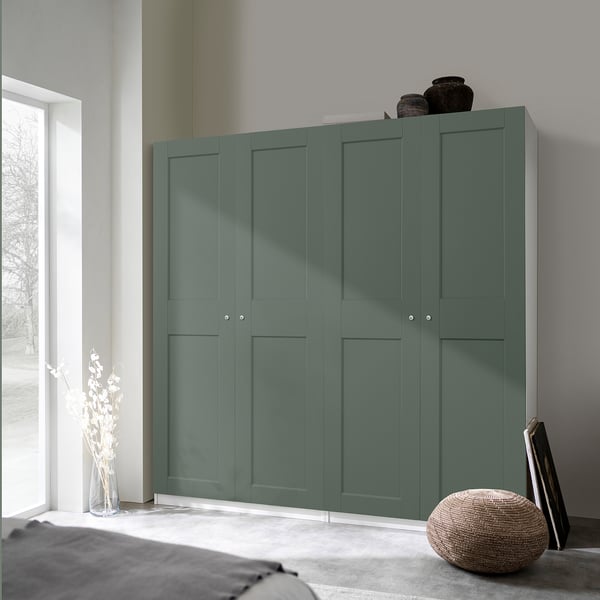 Modern green PAX wardrobe fits corner, tall with vases on top, near large window.