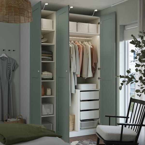 Green PAX wardrobe with open doors, showing organised clothes and storage.