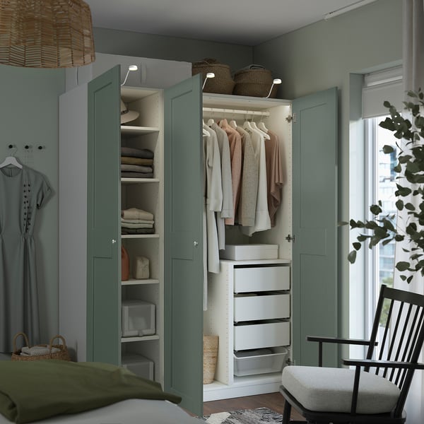 A well-organized wardrobe with green doors displays clothes, shelves, and drawers. Lighting inside reveals neatly arranged items.
