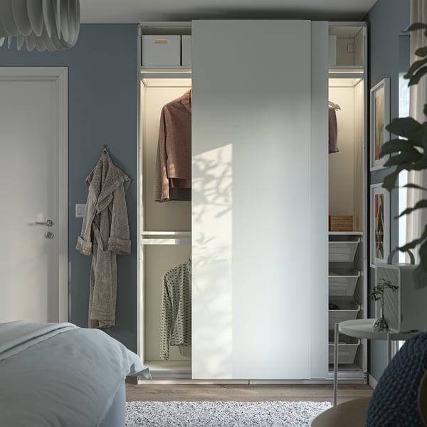 Modern bedroom featuring a PAX wardrobe with sliding doors and internal storage, optimising space and organisation.