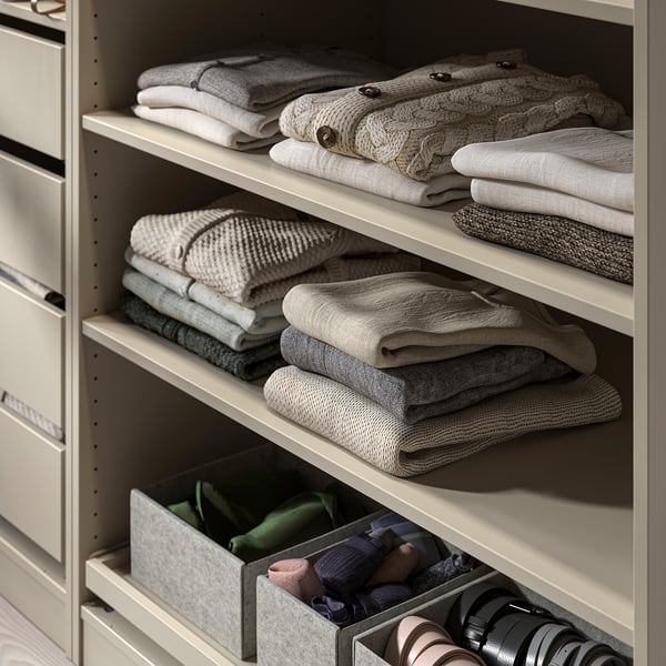 Closet with folded clothes on shelves, some items in mesh bins.