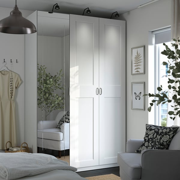 Modern bedroom with PAX wardrobe, mirrored and white doors, central lighting.