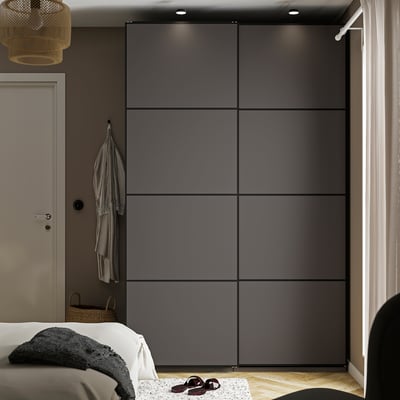 Minimalist bedroom with sleek grey PAX wardrobe, white bed, pendant lamp.