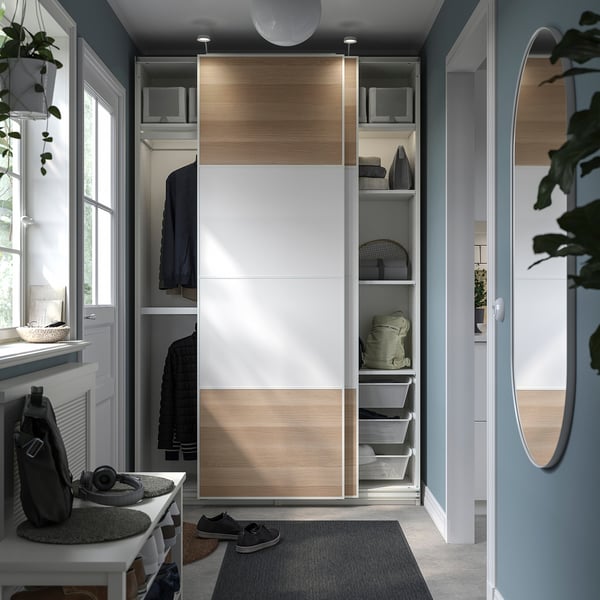 Modern closet with sliding doors, shelves, plants, natural light.