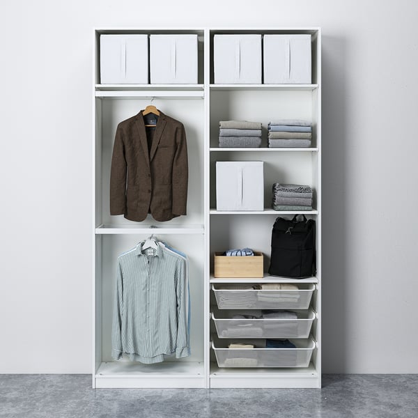 A modern, white wardrobe with hanging suits and shirts, folded clothes, baskets, and storage boxes, fixed to the wall for stability.
