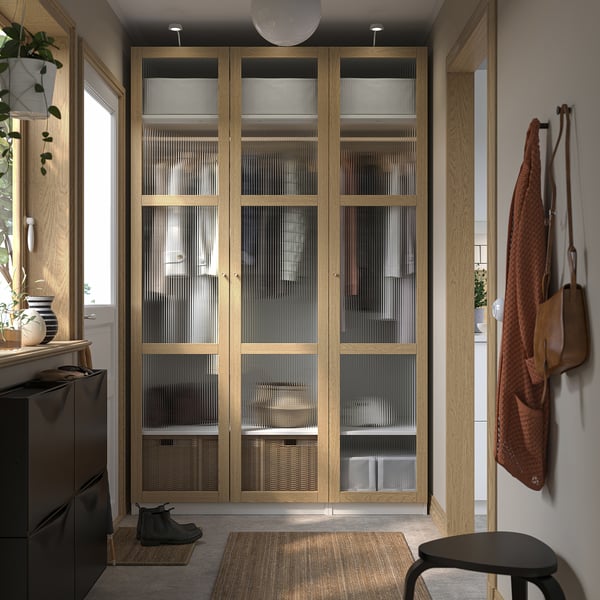 Wooden PAX wardrobe with glass doors, tall with coat and boots.