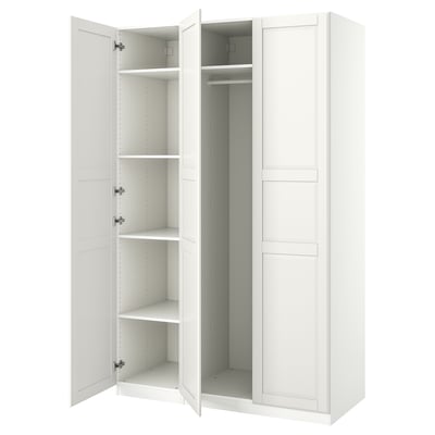 An open white IKEA PAX wardrobe with shelves and a hanging rod inside.