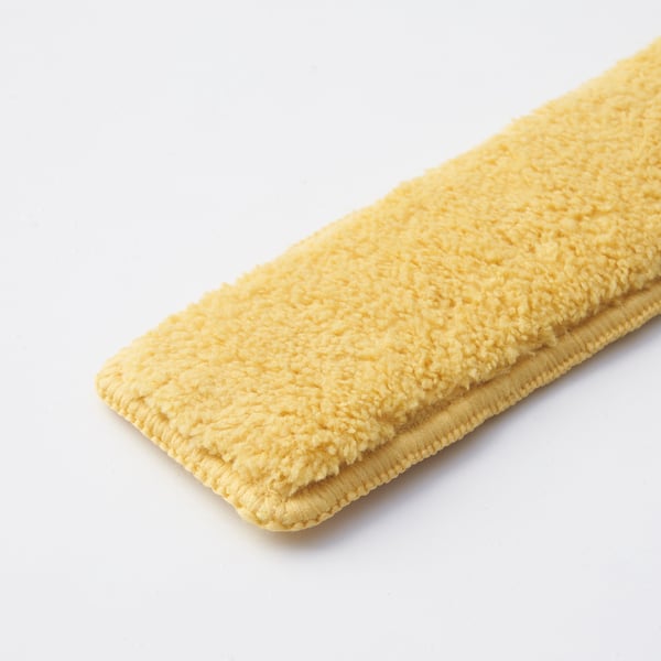 Folded yellow cleaning pad, soft textured surface, stitched edges, laid on white background.