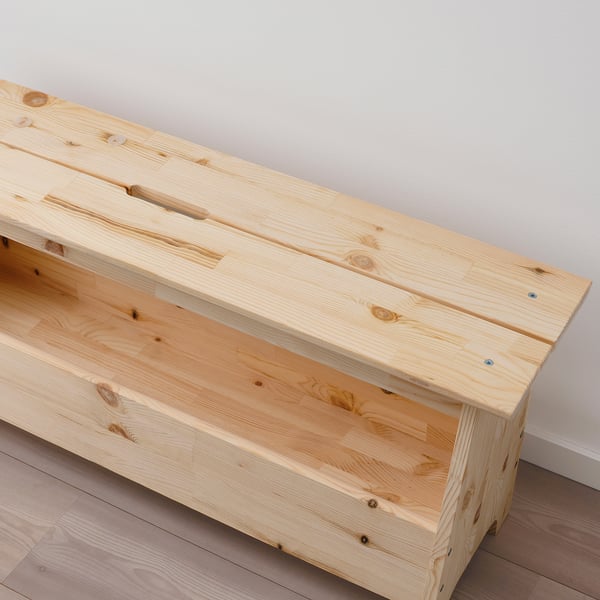 Minimalist pine bench, smooth finish, sturdy construction, natural wood grain visible, under-seat storage space.