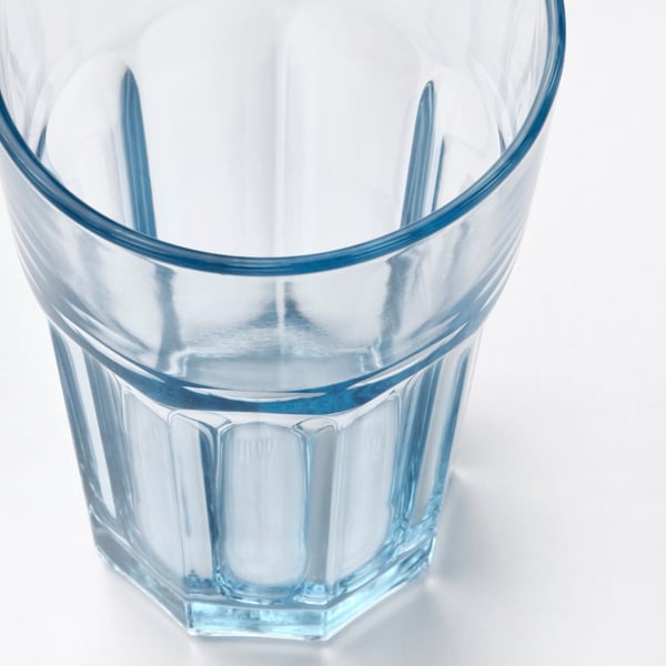 A translucent blue-tinted glass cup with a thick base and smooth edges, showcasing its sturdy and elegant design.