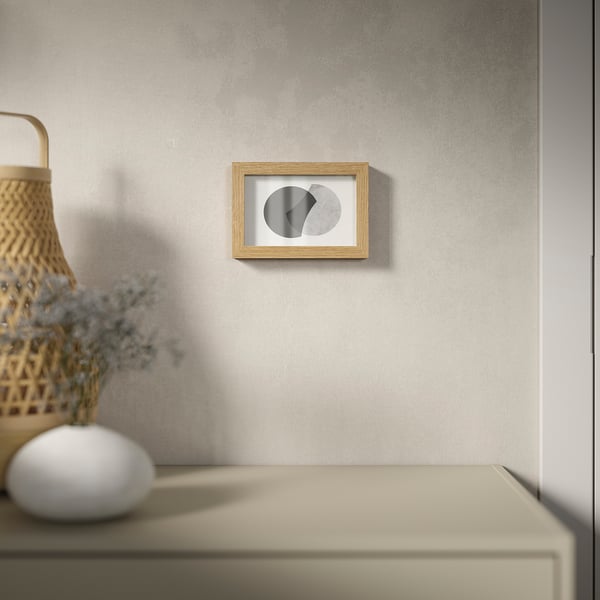 Minimalist framed art with geometric shapes hangs on wall, versatile for vertical/horizontal.