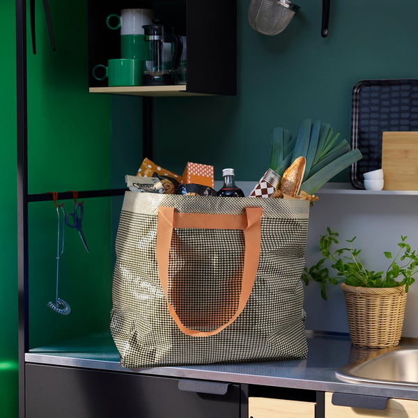 Large ROMELSÖN shopping bag, houndstooth pattern, metallic handles on kitchen counter.