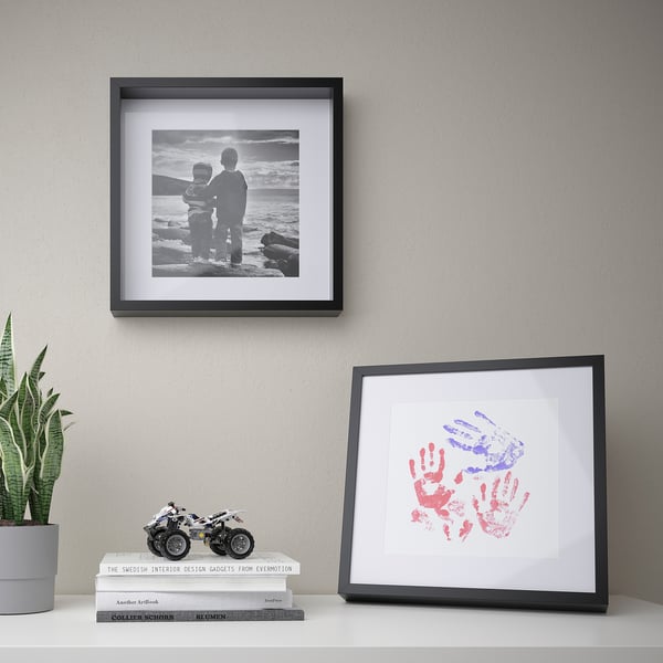 Framed sea trio, handprint art, books, motorcycle, snake plant.