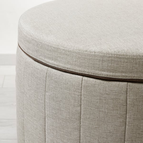 Close-up of a well-crafted, upholstered round ottoman with neat stitching and quality fabric.