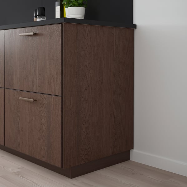 Elegant dark brown wooden SINARP kitchen cabinet or drawer with sleek metal handles set against a light-colored wall.