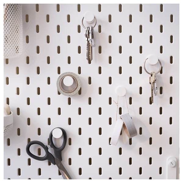 SKÅDIS pegboard with white hooks holds keys, scissors, and tape; perfect for home organisation.
